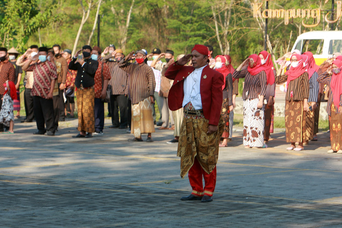 Petugas dan puluhan warga mengenakan pakaian adat Jawa saat mengikuti upacara peringatan HUT ke-76 Kemerdekaan RI di Kampung Jawi, Selasa (17/8/2021).