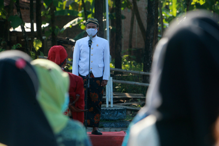Petugas dan puluhan warga mengenakan pakaian adat Jawa saat mengikuti upacara peringatan HUT ke-76 Kemerdekaan RI di Kampung Jawi, Selasa (17/8/2021).