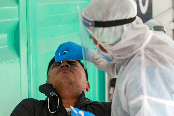 Petugas melakukan swab PCR kepada warga secara drive thru di GSI Lab, Jakarta Selatan, Selasa (17/8/2021).