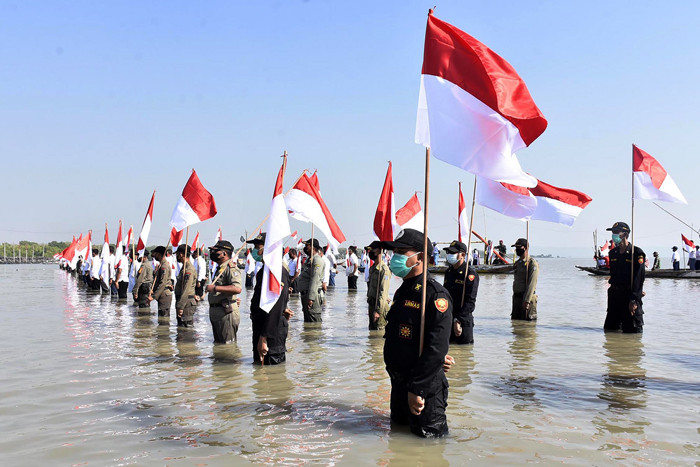 Upacara peringatan HUT Ke-76 Kemerdekaan Republik Indonesia di Sekitaran Suramadu, Kecamatan Kenjeran, Kota Surabaya, Jawa Timur, Selasa (17/8/2021).