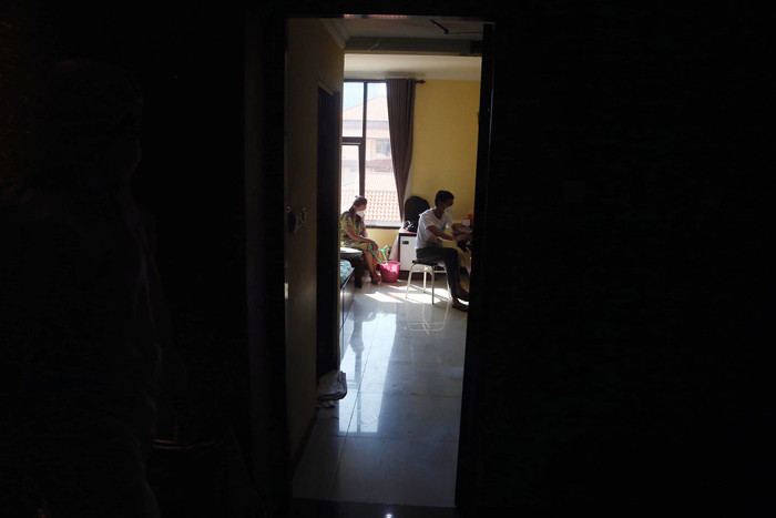 Pasien Covid-19 beraktifitas didalam kamar ketika menjalani isolasi di gedung isolasi Hotel Asrama Haji (HAH) Surabaya, Jawa Timur, Selasa (17/8/2021).