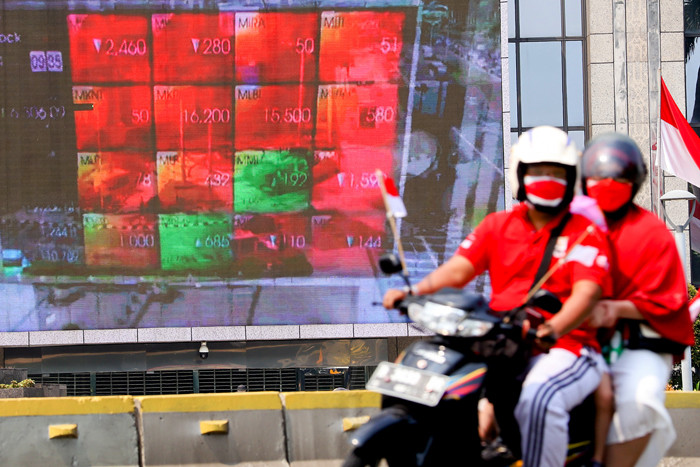 Pengendara saat melintas berlatar belakang tampilan iklan di gedung Bursa Efek Indonesia, Selasa (17/8/2021).