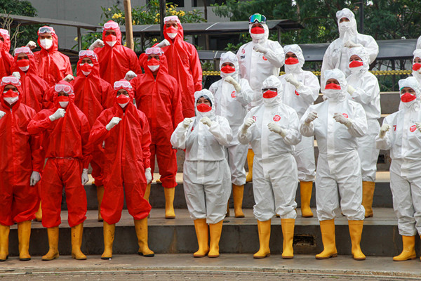 Tenaga kesehatan mengibarkan bendera merah putih saat upacara peringatan kemerdekaan Ke-76 RI di RSDC-19, Wisma Atlet, Jakarta, Selasa (17/8/2021).
