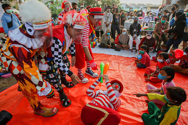 Sejumlah Badut yang tergabung dalam komunitas ABI menghibur anak-anak korban kebakaran di pengungsian kawasan Kemang Utara IX, Jakarta, Rabu (18/8/2021).