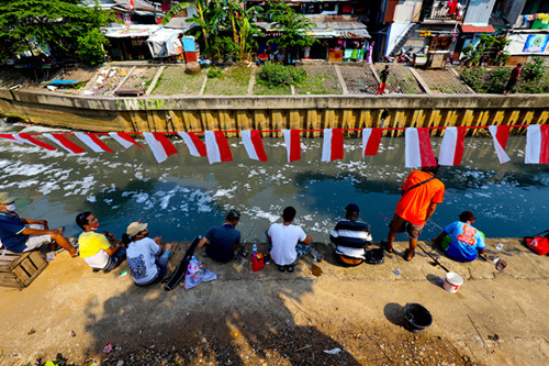 Warga mengikuti lomba mancing sambil berjemur dengan protokol kesehatan dalam rangka HUT Kemerdekaan ke-76 di Kali Grogol, Jakarta Barat, Selasa (17/8/2021).