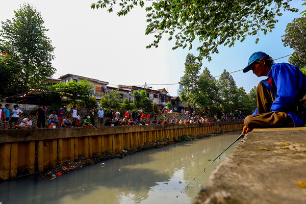 Warga mengikuti lomba mancing sambil berjemur dengan protokol kesehatan dalam rangka HUT Kemerdekaan ke-76 di Kali Grogol, Jakarta Barat, Selasa (17/8/2021).