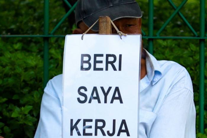 Seorang bapak berprofesi sebagai buruh tukang bangunan menunggu seseorang untuk mengajaknya bekerja di Kawasan Jakarta Pusat, Kamis (19/8/2021).