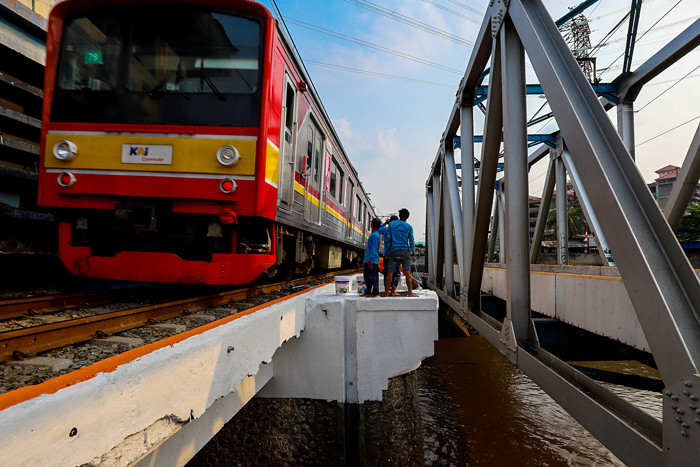 Pekerja saat mengecat bangunan pintu air petamburan, kali ciliwung, Jakarta Pusat, Kamis (19/8/2021).