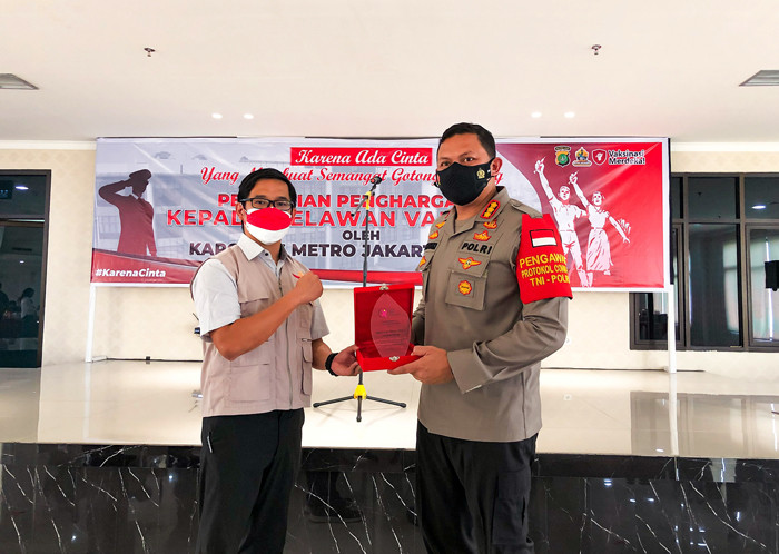 Kapolres Metro Jakpus Kombes Hengki Haryadi memberikan piagam penghargaan kepada relawan Vaksinasi Merdeka di Polres Metro Jakarta Pusat, Jumat (20/8/2021).