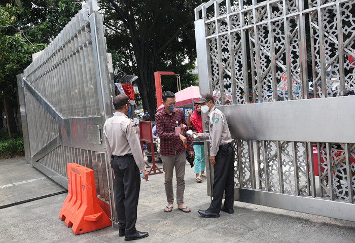 Petugas keamanan mengecek suhu badan warga yang akan menunaikan shalat Jumat di Masjid Istiqlal, Jakarta, Jumat (20/8/2021).