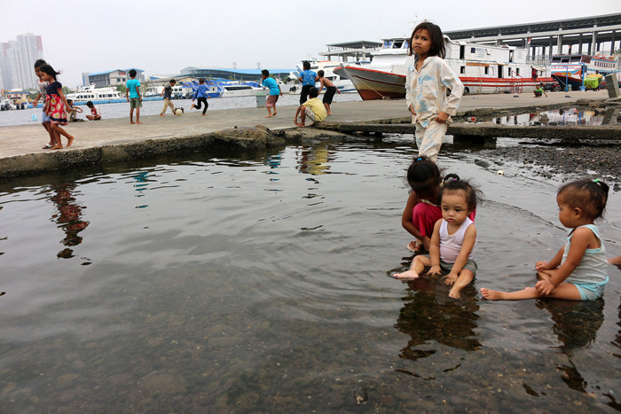 Warga dan anak-anak bermain di kawasan Pelabuhan Kaliadem, Muara Angke, Jakarta, Sabtu (21/8/2021).