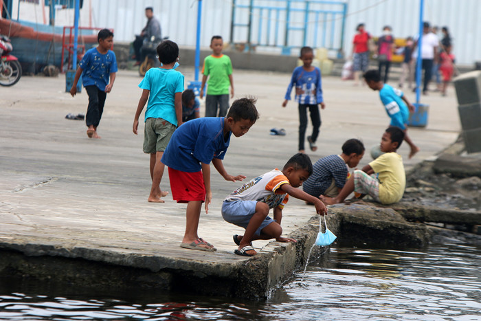 Warga dan anak-anak bermain di kawasan Pelabuhan Kaliadem, Muara Angke, Jakarta, Sabtu (21/8/2021).