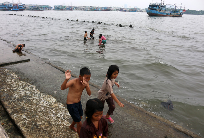 Warga dan anak-anak bermain di kawasan Pelabuhan Kaliadem, Muara Angke, Jakarta, Sabtu (21/8/2021).