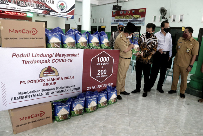 Warga mengambil jatah beras di Desa Tambak Sumur, Waru, Sidoarjo, Jawa Timur, Senin (23/8/2021).