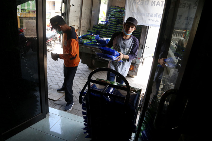 Warga mengambil jatah beras di Desa Tambak Sumur, Waru, Sidoarjo, Jawa Timur, Senin (23/8/2021).