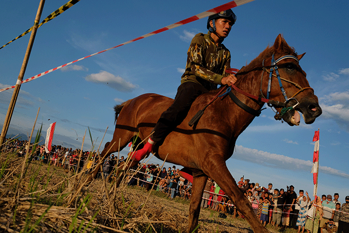 Sejumlah warga menyaksikan pacuan kuda tradisional di Kecamatan Simbang, Desa Tanete, Kabupaten Maros, Rabu (25/8/2021).