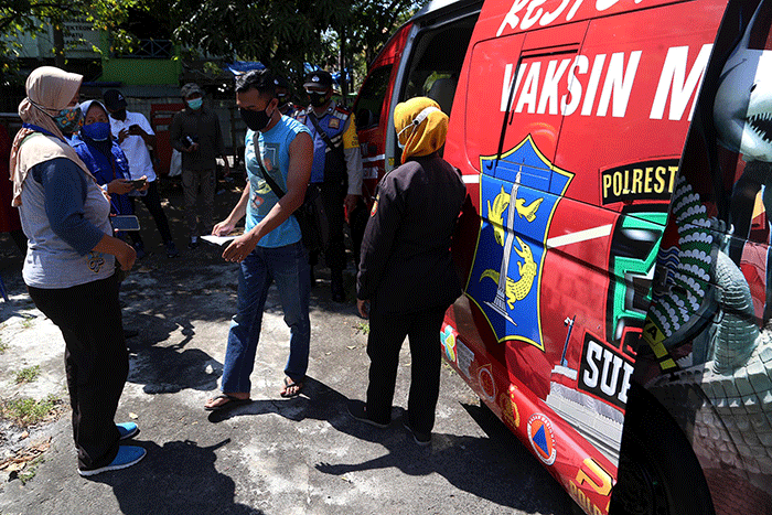 Warga mendapatkan suntikan vaksin dosis kedua di Mobil Vaksin Keliling saat berhenti di Balai RW 11 Kalirungkut Surabaya, Jawa Timur, Rabu (25/8/2021).