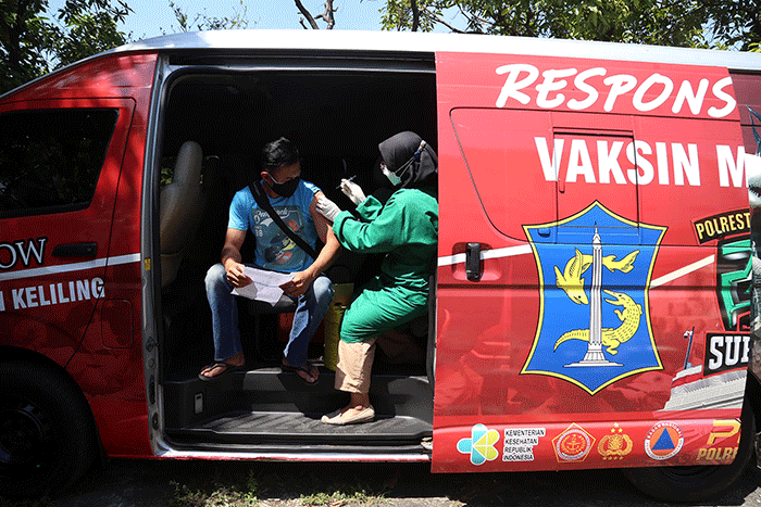 Warga mendapatkan suntikan vaksin dosis kedua di Mobil Vaksin Keliling saat berhenti di Balai RW 11 Kalirungkut Surabaya, Jawa Timur, Rabu (25/8/2021).