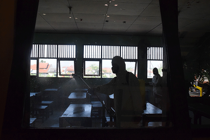 Sejumlah personel Kompi 1 Batalyon A Pelopor Brimob Srondol Semarang melakukan penyemprotan disinfektan di SMP Negeri 27, Semarang, Kamis (26/8/2021).