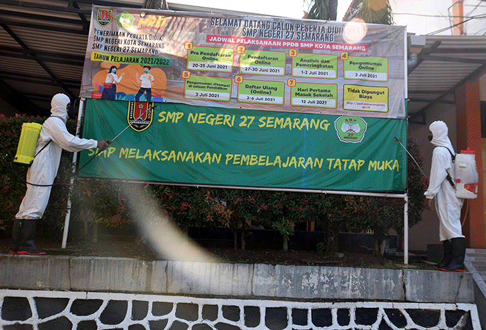 Sejumlah personel Kompi 1 Batalyon A Pelopor Brimob Srondol Semarang melakukan penyemprotan disinfektan di SMP Negeri 27, Semarang, Kamis (26/8/2021).
