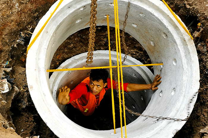 Pekerja sedang menyelesaikan pembuatan drainase vertikal atau sumur resapan di trotoar jalan Gatot Subroto, Jakarta Selatan, Jumat (27/8/2021).