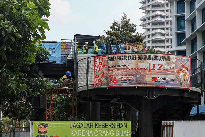 Pekerja menyelesaikan pembangunan Jembatan Penyebrangan Sepeda sekaligus JPO di Jalan Sudirman, Karet Tengsin, Jakarta Pusat, Sabtu (28/8/2021).