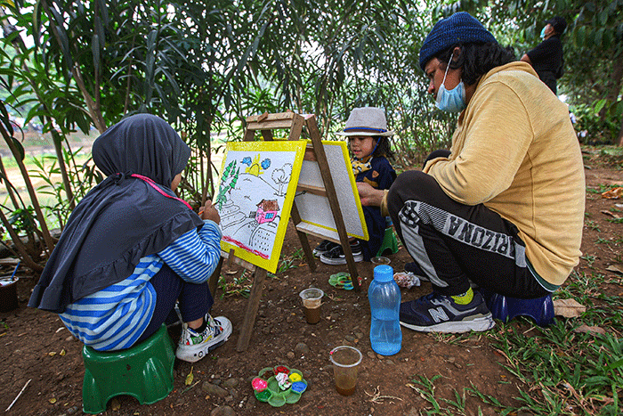 Seorang anak menunjukan hasil karya mewarnai miliknya di kawasan Banjir Kanal Timur, Jakarta, Minggu (29/8/2021).