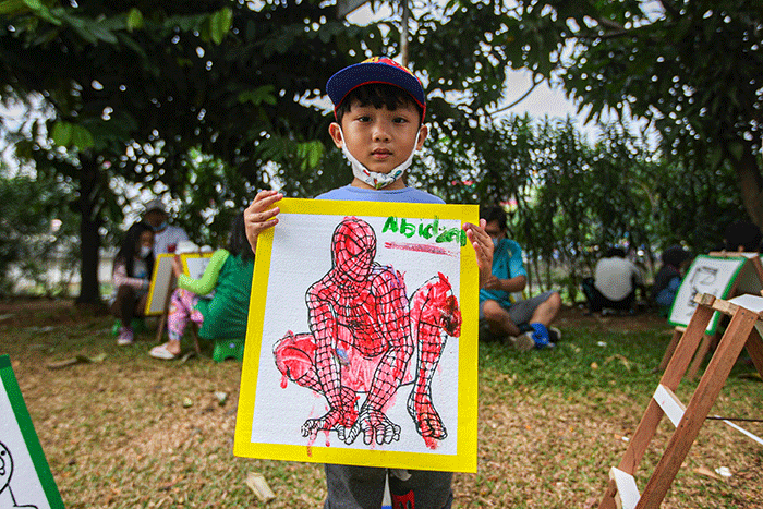 Seorang anak menunjukan hasil karya mewarnai miliknya di kawasan Banjir Kanal Timur, Jakarta, Minggu (29/8/2021).