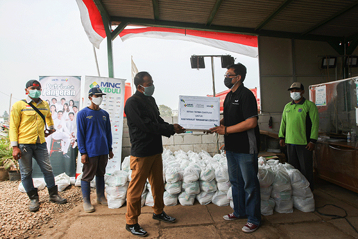 Head of CSR MNC Group Tengku Hafid memberikan paket sembako ke perwakilan petugas pemakaman jenazah Covid-19 di TPU Rorotan, Jakarta Utara, Senin (30/8/2021).