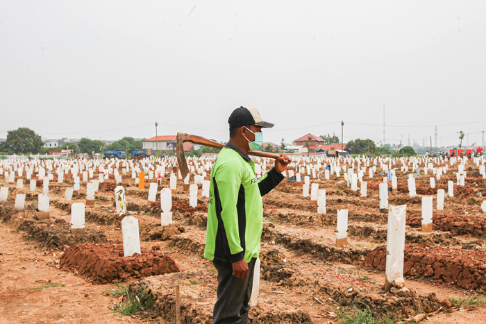 Petugas pemakaman saat melakukan perawatan tanah makam yang ambles akibat hujan di Taman Pemakaman Umum Rorotan, Jakarta Utara, Senin (30/8/2021).