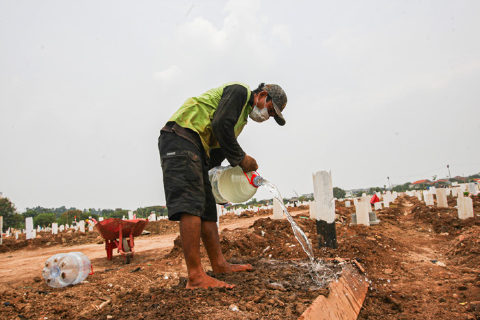 Petugas pemakaman saat melakukan perawatan tanah makam yang ambles akibat hujan di Taman Pemakaman Umum Rorotan, Jakarta Utara, Senin (30/8/2021).