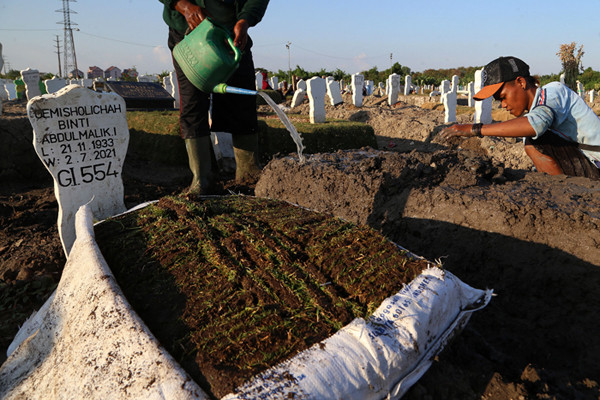 Pekerja melakukan perawatan makam khusus Covid-19 di TPU Keputih Surabaya, Jawa Timur, Rabu (1/9/2021).