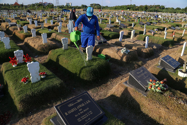 Pekerja melakukan perawatan makam khusus Covid-19 di TPU Keputih Surabaya, Jawa Timur, Rabu (1/9/2021).