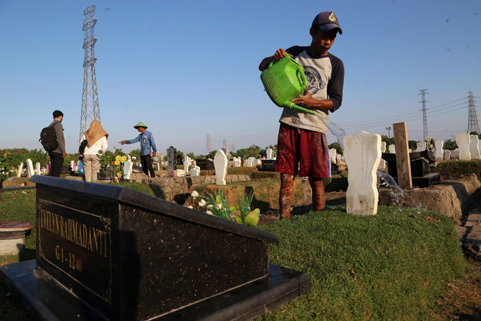 Pekerja melakukan perawatan makam khusus Covid-19 di TPU Keputih Surabaya, Jawa Timur, Rabu (1/9/2021).