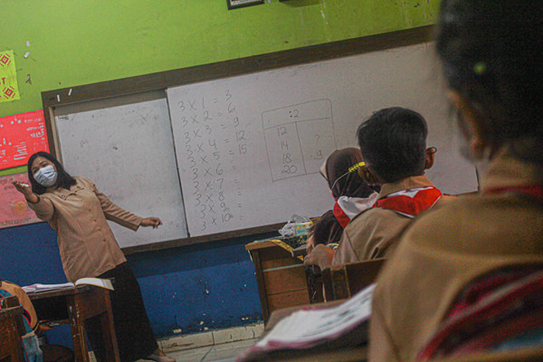 Seorang Guru menerangkan materi pembelajaran kepada murid secara tatap muka terbatas di SDN Semper Barat 01 Pagi, Jakarta, Rabu (1/9/2021).