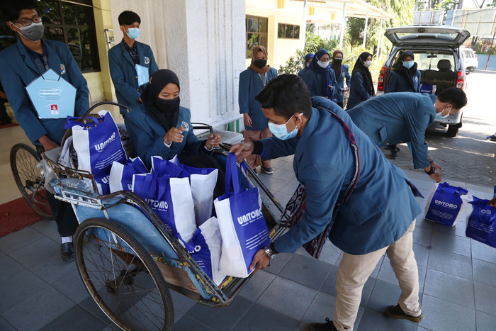 Mahasiswa Baru Universitas Dr Soetomo Surabaya membagikan sembako pada warga kurang mampu di sekitar kampus Unitomo Surabaya, Jawa Timur, Jumat (3/9/2021).