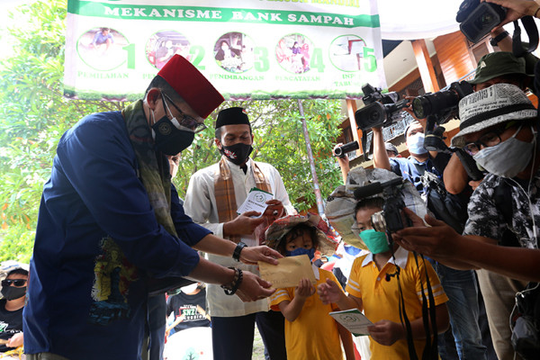 Menteri Pariwisata dan Ekonomi Kreatif Sandiaga Uno menyerahkan hasil tabungan kepada siswa yang menjadi nasabah BSPM di Jakarta, Jumat (3/9/2021).