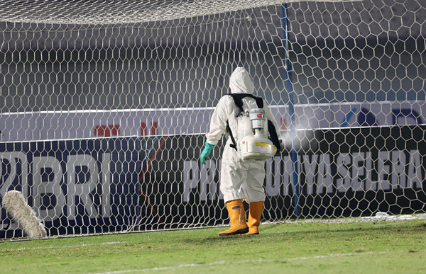 Petugas menyemprotkan cairan disinfektan saat pertandingan laga Liga 1 di Stadion Indomilk Arena, Tangerang, Banten, Sabtu (4/9/2021).