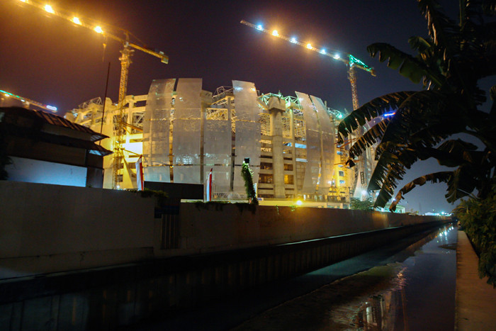 Aktivitas pekerja proyek tampak dari luar di area pembangunan Jakarta International Stadium, Sunter Agung, Tanjung Priok, Jakarta Utara, Senin (6/9/2021).