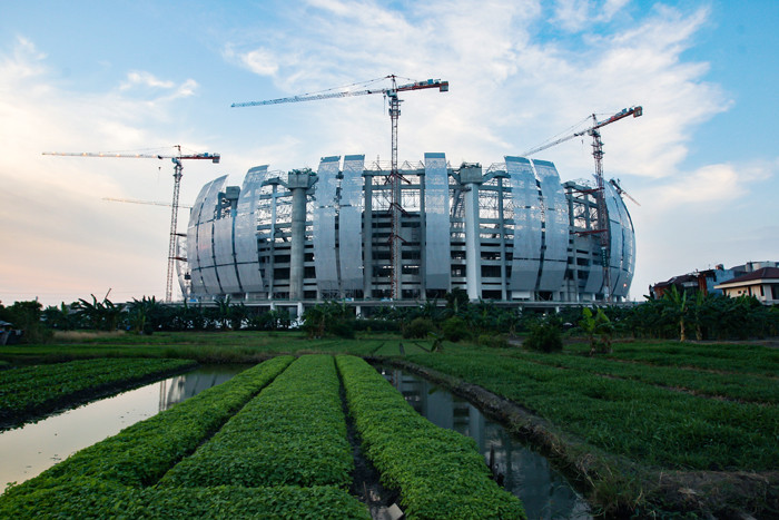 Aktivitas pekerja proyek tampak dari luar di area pembangunan Jakarta International Stadium, Sunter Agung, Tanjung Priok, Jakarta Utara, Senin (6/9/2021).