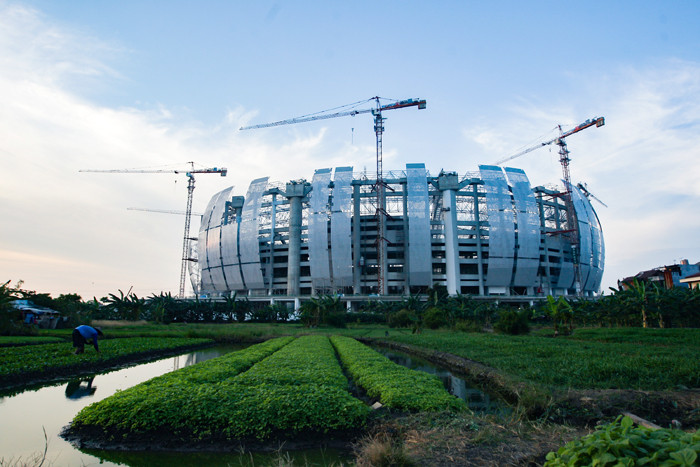 Petani merawat sayuran yang ditanam di lahan garapan dekat proyek pembangunan Jakarta International Stadium (JIS), Jakarta Utara, Senin (6/9/2021).