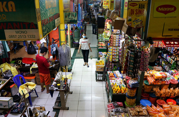 Pedagang menjaga toko sembakonya yang dipasang stiker sertifikat vaksin Covid-19 di Pasar Santa, Jakarta Selatan, Senin (6/9/2021).
