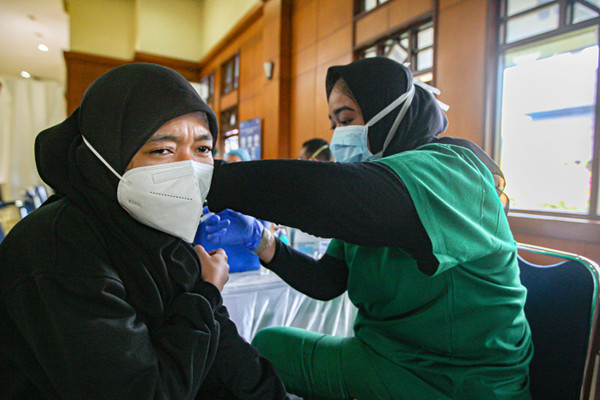 Warga saat menerima suntikan dosis vaksin Covid-19 jenis AstraZeneca di Gedung Padepokan Pencak Silat, Taman Mini, Jakarta Timur, Selasa (7/9/2021).