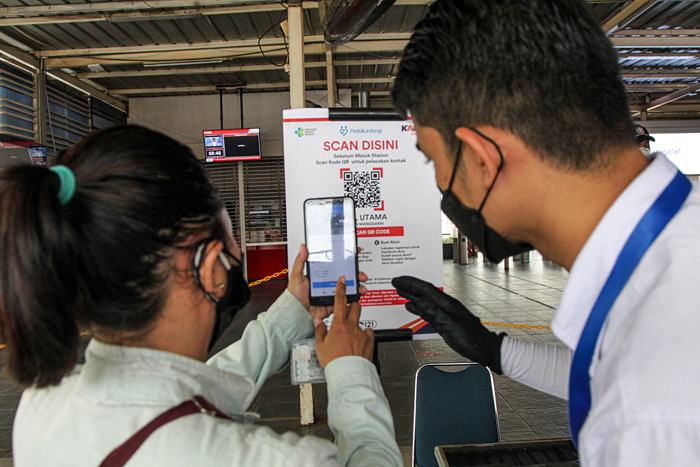 Calon penumpang memindai kode batang dari aplikasi PeduliLindungi sebelum melakukan perjalanan di Stasiun Manggarai, Jakarta, Selasa (7/9/2021).