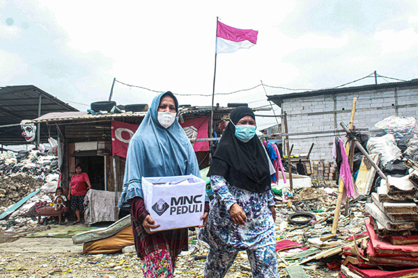 Relawan membagikan masker dengan cara door to door ke rumah warga di Tanah Merah, Jakarta Utara, Kamis (9/9/2021).