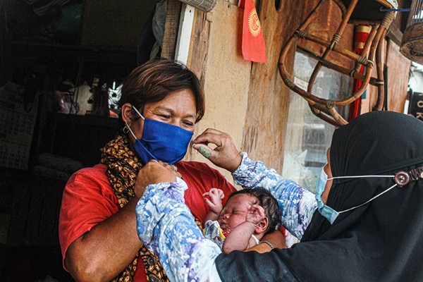 Relawan membagikan masker dengan cara door to door ke rumah warga di Tanah Merah, Jakarta Utara, Kamis (9/9/2021).