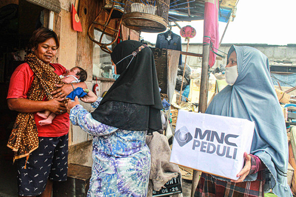 Relawan membagikan masker dengan cara door to door ke rumah warga di Tanah Merah, Jakarta Utara, Kamis (9/9/2021).