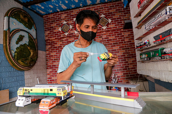 Iskandar (52) menyelesaikan pembuatan miniatur kereta api di kiosnya di Kawasan Manggarai, Jakarta Selatan, Sabtu (11/9/2021).