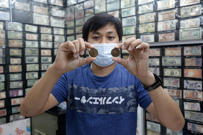 Seorang penjual uang kuno, David menunjukkan uang kuno koin Rp2 perak tahun 1945 di tokonya di kawasan pertokoan Pasar Baru, Jakarta Pusat, Sabtu (11/9/2021).