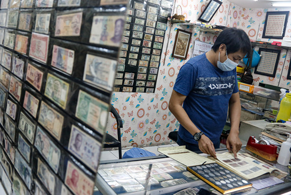 Seorang penjual uang kuno, David menunjukkan uang kuno koin Rp2 perak tahun 1945 di tokonya di kawasan pertokoan Pasar Baru, Jakarta Pusat, Sabtu (11/9/2021).